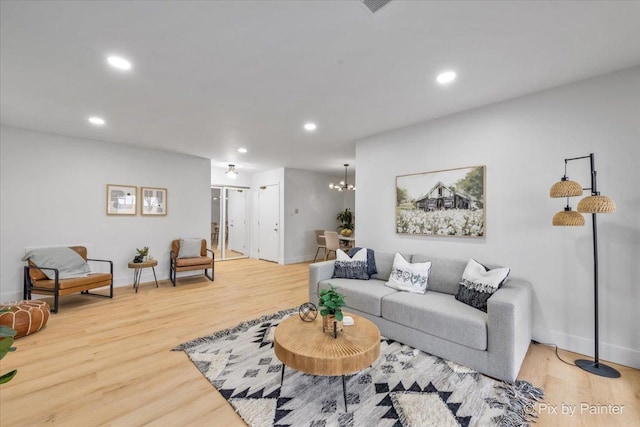 living room with a chandelier, recessed lighting, baseboards, and wood finished floors