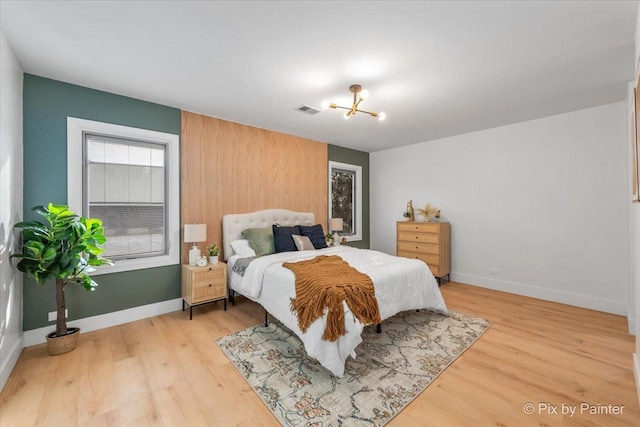 bedroom with light wood-type flooring, baseboards, and visible vents