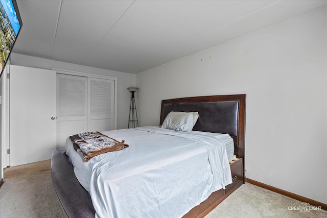 carpeted bedroom featuring a closet and baseboards