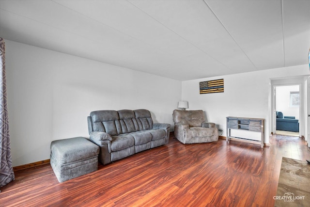 living area with baseboards and wood finished floors