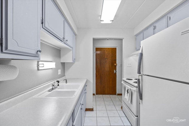 kitchen with under cabinet range hood, light countertops, light tile patterned floors, white appliances, and a sink