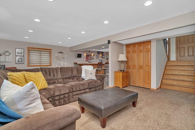 living area featuring baseboards, stairway, light colored carpet, and recessed lighting