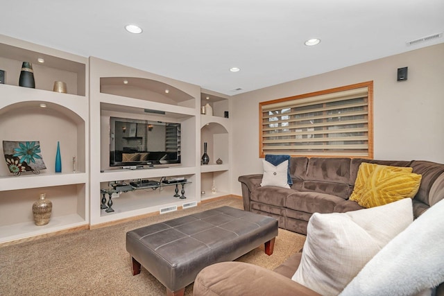 carpeted living area featuring built in shelves, visible vents, and recessed lighting