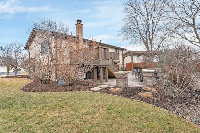 rear view of house with a yard, a chimney, an outdoor fire pit, a patio area, and stairs