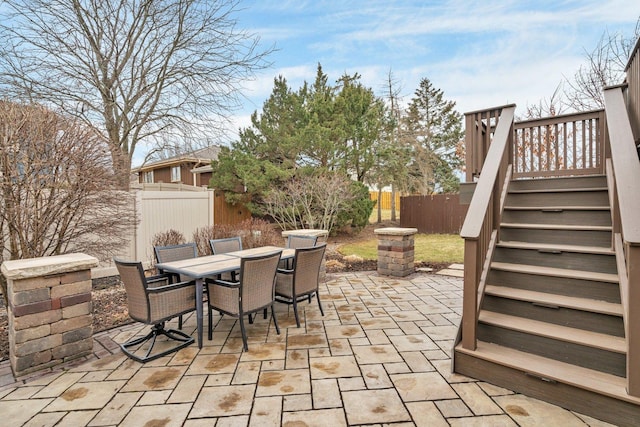 view of patio / terrace featuring a fenced backyard, stairs, and outdoor dining area