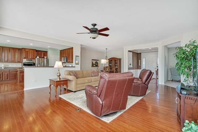 living area with recessed lighting, ceiling fan, and light wood finished floors