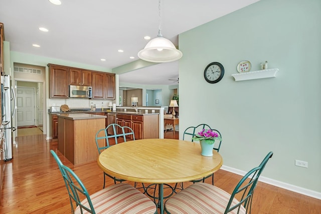 dining space with recessed lighting, ceiling fan, light wood-style flooring, and baseboards