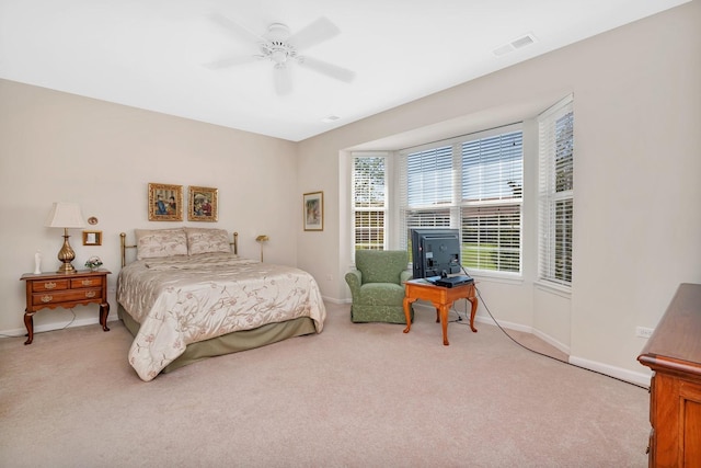 bedroom featuring a ceiling fan, light colored carpet, visible vents, and baseboards