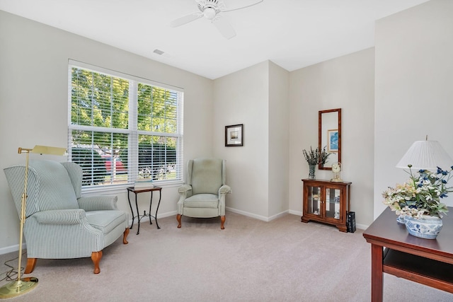 living area featuring carpet floors, baseboards, visible vents, and ceiling fan