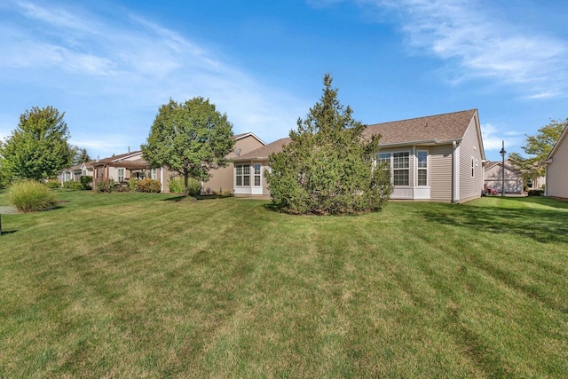 rear view of property featuring a yard