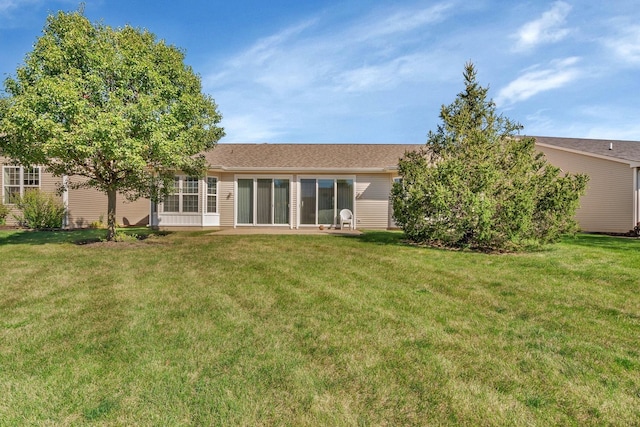 rear view of property featuring a yard