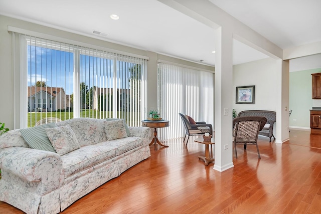 living room with light wood-type flooring, baseboards, visible vents, and recessed lighting