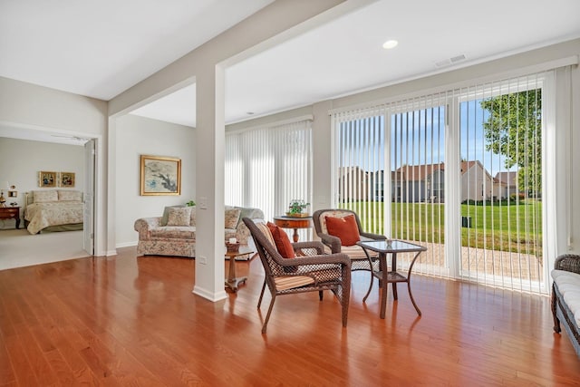 living area featuring visible vents and wood finished floors