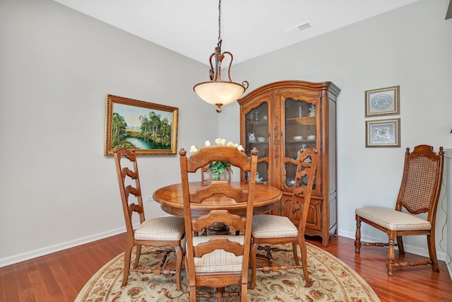 dining area with visible vents, baseboards, and wood finished floors