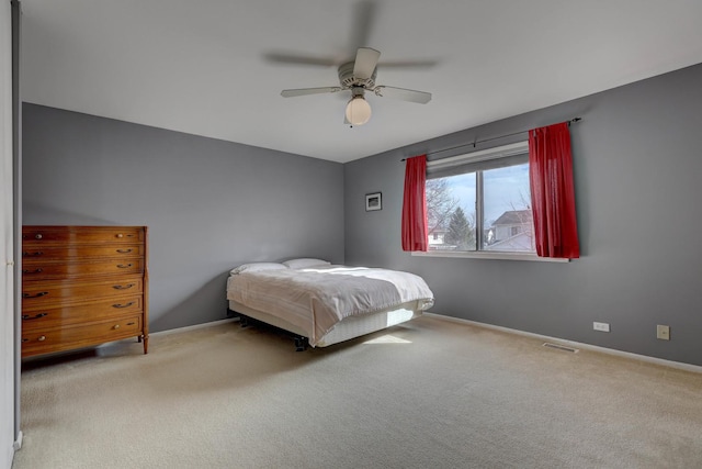 unfurnished bedroom with carpet floors, a ceiling fan, visible vents, and baseboards