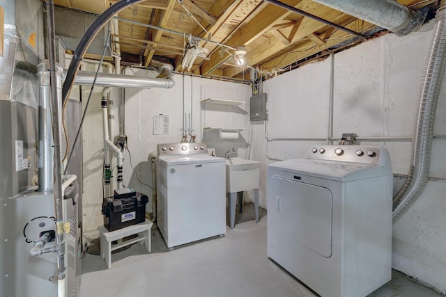 clothes washing area with laundry area, heating unit, electric panel, and washer and dryer