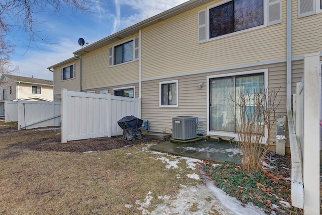 rear view of house with fence and central AC