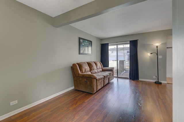 living area with dark wood-style floors, baseboards, and beamed ceiling