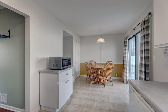 dining area with light tile patterned flooring, visible vents, and baseboards