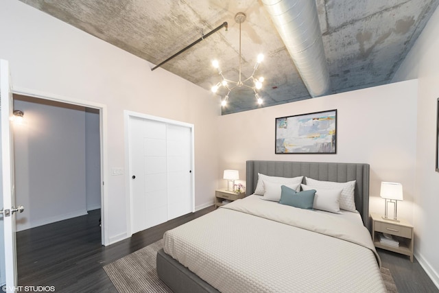 bedroom featuring a notable chandelier, a closet, baseboards, and wood finished floors