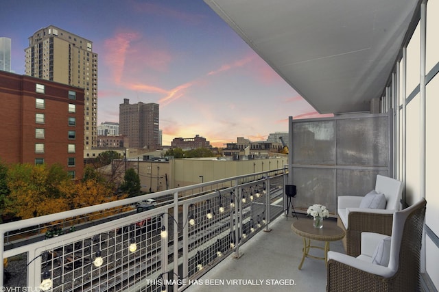 balcony at dusk featuring a view of city