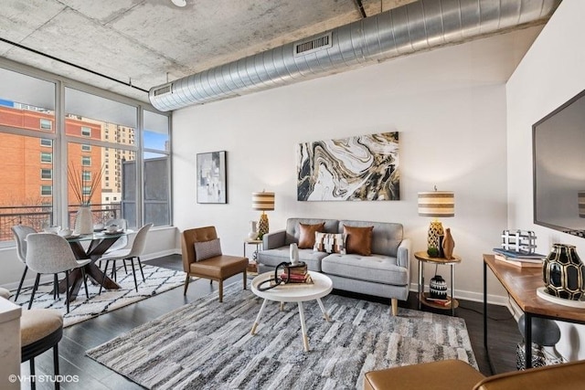 living area with visible vents, baseboards, and wood finished floors