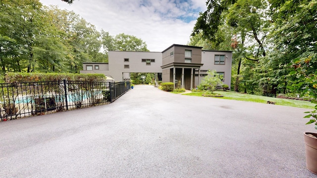 view of front of house featuring a fenced in pool and fence