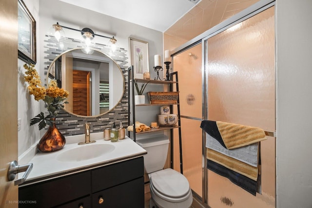 bathroom with a shower stall, backsplash, toilet, and vanity