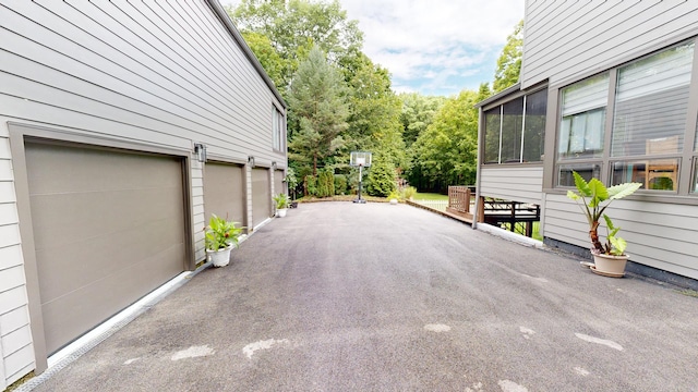 exterior space featuring a garage, driveway, and a sunroom