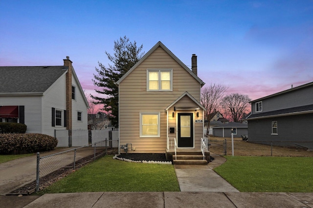 traditional-style house featuring a chimney, a front yard, and fence