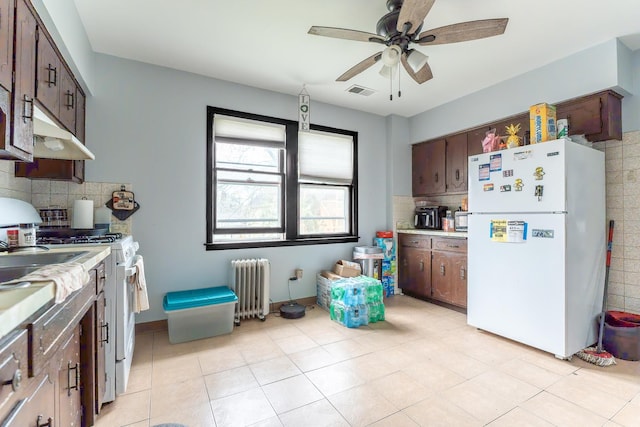 kitchen featuring white appliances, visible vents, radiator, light countertops, and backsplash