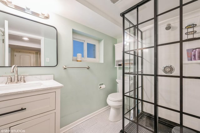 full bath featuring toilet, vanity, baseboards, tiled shower, and tile patterned floors