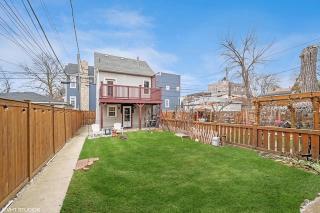 rear view of property with a fenced backyard and a yard