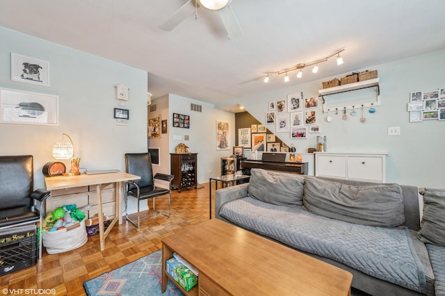 living room featuring a ceiling fan and visible vents