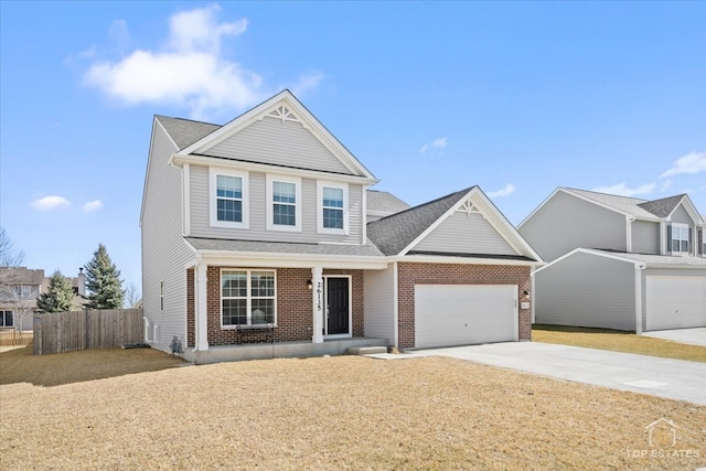 traditional home featuring concrete driveway, an attached garage, fence, and brick siding