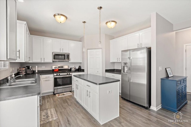 kitchen featuring dark countertops, white cabinets, and appliances with stainless steel finishes