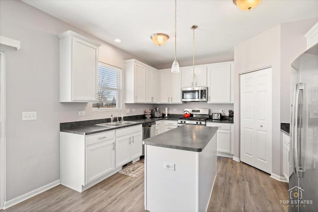 kitchen with dark countertops, appliances with stainless steel finishes, and white cabinetry