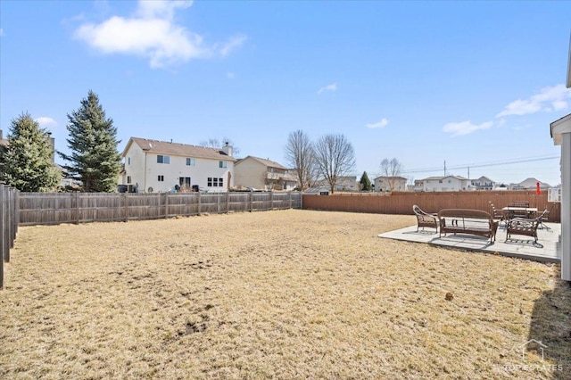 view of yard featuring outdoor lounge area, a patio, a fenced backyard, and a residential view