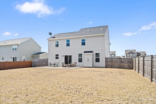 rear view of house featuring a yard, a patio, and a fenced backyard