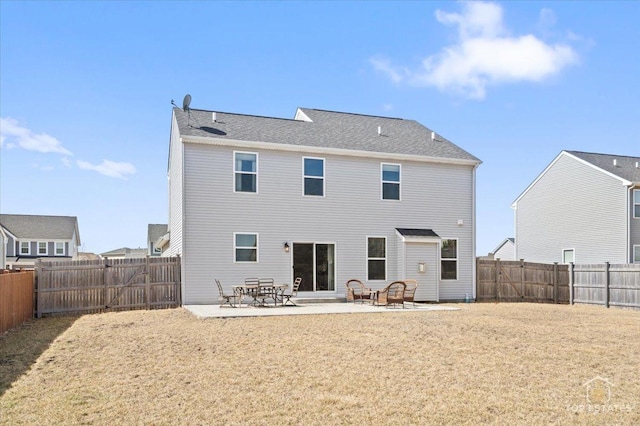 rear view of property with a lawn, a fenced backyard, and a patio area