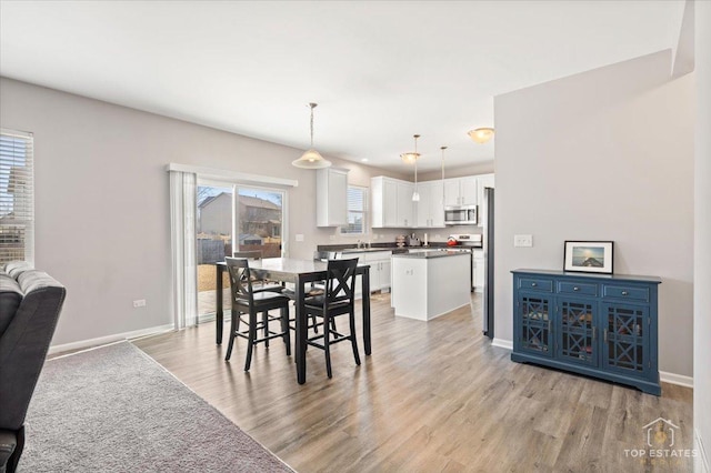 dining area with baseboards and light wood-type flooring