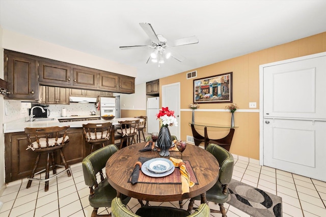 dining room featuring visible vents, light tile patterned flooring, and a ceiling fan