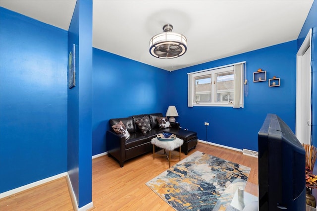 sitting room featuring visible vents, baseboards, and wood finished floors