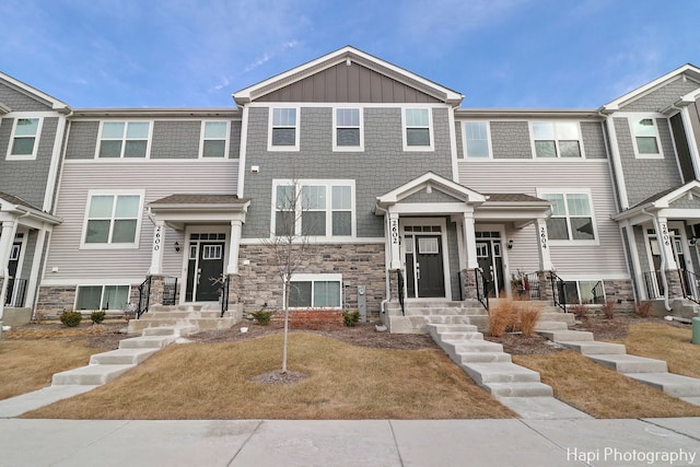 townhome / multi-family property featuring stone siding and board and batten siding