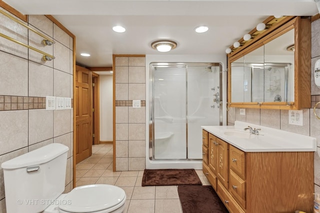 bathroom featuring a stall shower, tile walls, toilet, and tile patterned floors