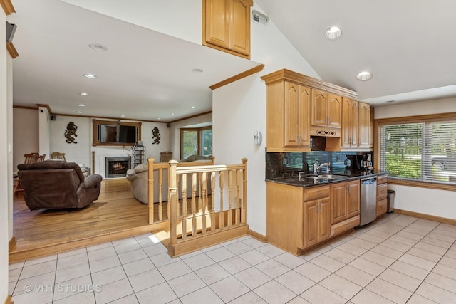 kitchen with light tile patterned floors, a lit fireplace, stainless steel dishwasher, ornamental molding, and tasteful backsplash