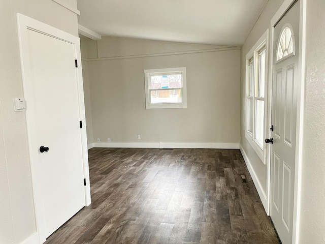 interior space with lofted ceiling, dark wood-style flooring, and baseboards