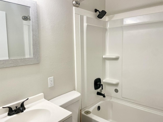 full bath featuring a textured wall, shower / bath combination, vanity, and toilet