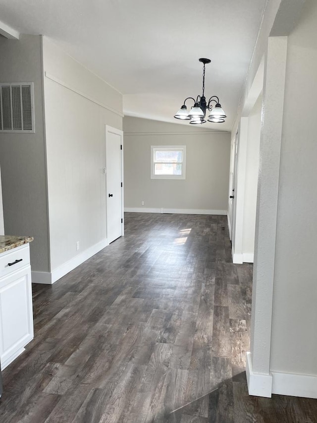 unfurnished dining area featuring dark wood-style floors, a chandelier, visible vents, and baseboards