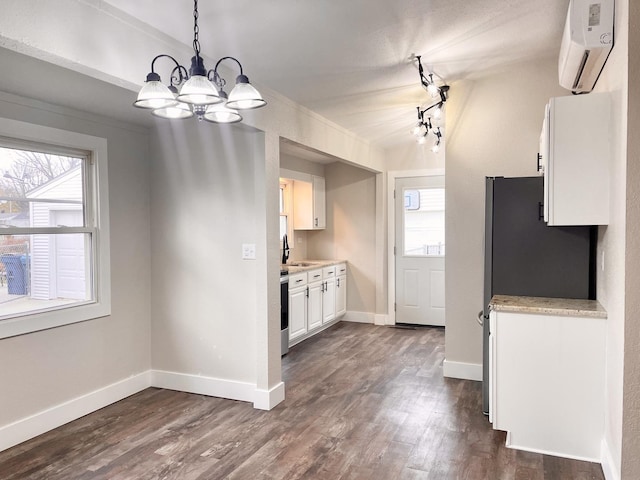 kitchen with an AC wall unit, dark wood-type flooring, and plenty of natural light